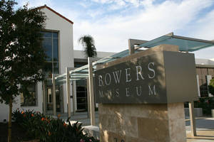 Bowers Museum 入口，現代建築風格，藍天下有石牌。