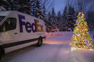 FedEx貨車停泊在黃昏時分雪地森林中一棵照明的聖誕樹旁。