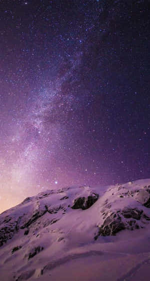 在繁星點點的紫色夜空下的雪峰，銀河可見。