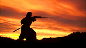 武士剪影在夕陽下揮劍。 — 武士 壁紙