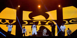 Wu-Tang Clan表演者在音樂會上於明亮燈光下在舞台上表演。