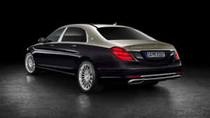 時尚的Maybach S600豪華轎車，在深色反光路面上配有紅色尾燈。
