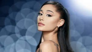 Ariana Grande 在工作室肖像中，背景為藍色散景，可見紋身。 — 靚女gif 壁紙