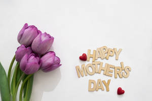 紫色鬱金香和木製Happy Mother's Day字母，配上紅色心形。