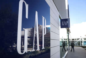 GAP商店外觀，大型白色字母反射天空和樹木，行人走過。