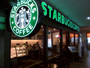 夜晚的Starbucks咖啡店店面，帶有發光的綠色招牌和玻璃窗。