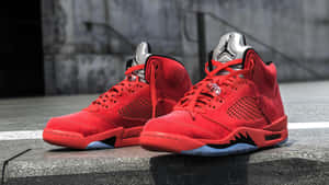 在城市環境中的混凝土階梯上的紅色Jordan 5運動鞋。 — Air Jordan GIF 壁紙