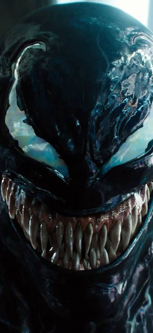 Venom 威脅性臉部的特寫，帶有鋒利牙齒和發光的眼睛。