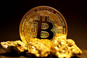一枚金色比特幣硬幣被金塊包圍在黑暗表面上。