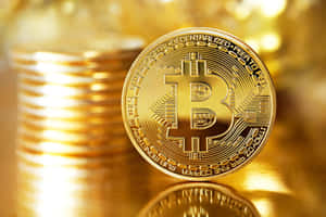 一枚閃閃發光的金色比特幣硬幣，背景有一堆模糊的硬幣。