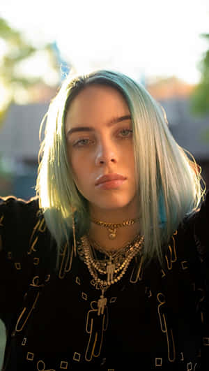 Billie Eilish 藍色頭髮和層疊項鍊，在金色光線中。