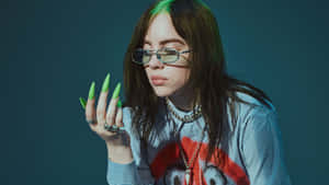 Billie Eilish 在攝影棚拍攝中展示綠色指甲和眼鏡。