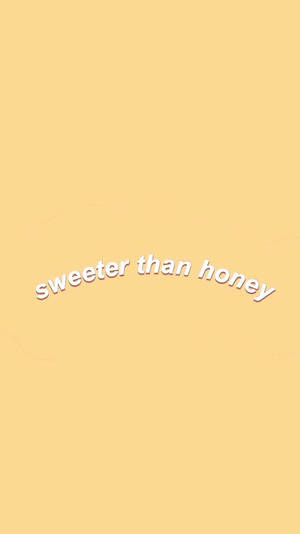 簡約壁紙，淡黃色背景上帶有白色彎曲文字，寫著「sweeter than honey」。 — 淡彩風格 壁紙