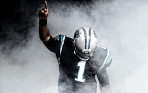 身穿黑色和青綠色球衣的美式足球員穿過煙霧向上指。 — NFL 美式足球 GIF 壁紙
