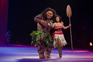現場表演期間，Moana 和 Maui 角色穿著戲服在燈光舞台上。