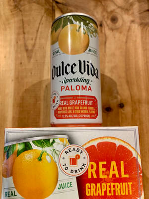 一罐和一盒西柚味即飲氣泡帕洛瑪在木頭上。