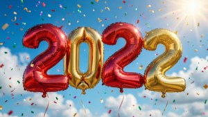 紅色和金色 2022 氣球，紙屑在藍天中飄落。