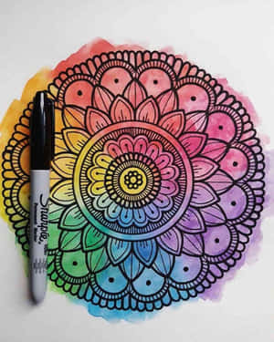 一幅彩色曼陀羅畫作，旁邊有一支Sharpie記號筆。