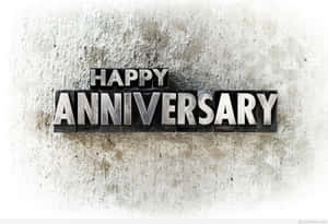 金屬活字塊在混凝土牆上拼出 happy anniversary。