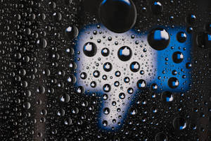 玻璃上的雨滴，背後有模糊的豎起大拇指符號。