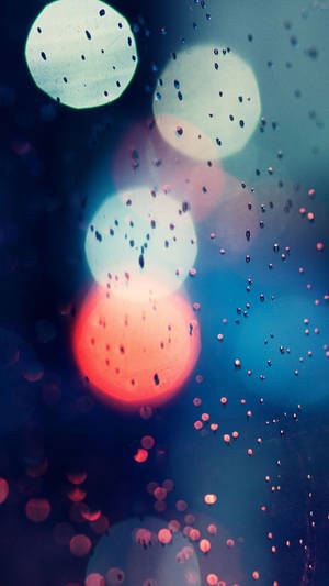 玻璃上的雨滴創造出模糊發光的紅色、藍色和白色燈光。 — 秋天 壁紙