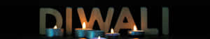 五盞點燃的茶蠟燭在木製DIWALI字母前溫暖地發光。