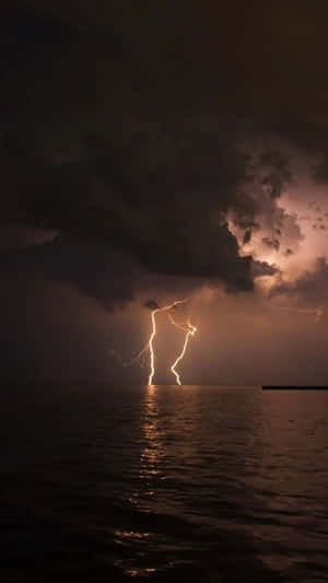 暴風夜空下黑暗海面上的閃電