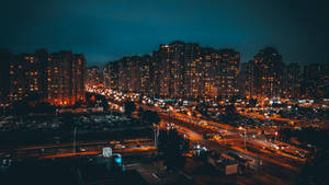 夜間城市景觀，燈火通明的建築和繁忙的街道。