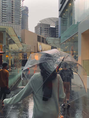 人在城市小巷中持透明雨傘雨中行走。