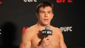 赤裸上身的UFC拳手在記者會上對著咪高峰說話。