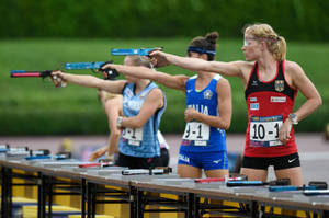 女運動員在比賽期間於射擊場瞄準氣手槍。