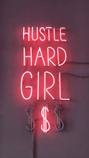 紅色霓虹燈牌，上面寫著 'HUSTLE HARD GIRL'，下方有美元符號，安裝在紫色牆上。