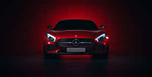 紅色 Mercedes-AMG GTS 跑車在黑暗的攝影棚中以紅色燈光照亮。