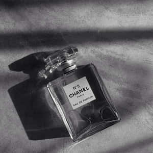 Chanel No 5 香水瓶放在布料上，帶有強烈陰影。 — 暗色 壁紙