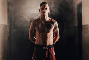一位赤裸上身、帶有紋身的男性UFC拳手站在煙霧瀰漫的走廊中。 — 運動 壁紙