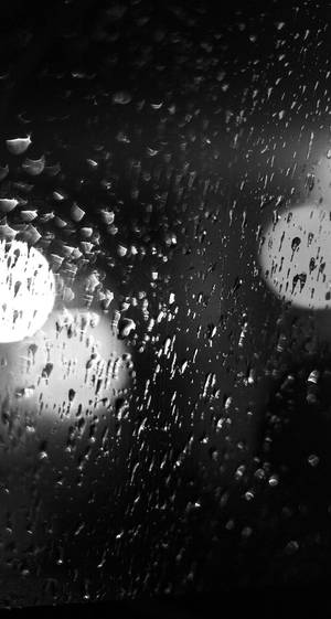 車窗上的雨滴，背景是模糊的城市燈光。