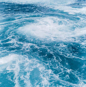 洶湧的藍色海水旋轉成泡沫漩渦。