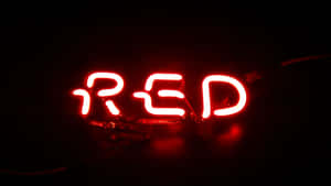 在黑暗的房間中，一個發光的紅色霓虹燈牌拼寫著RED。