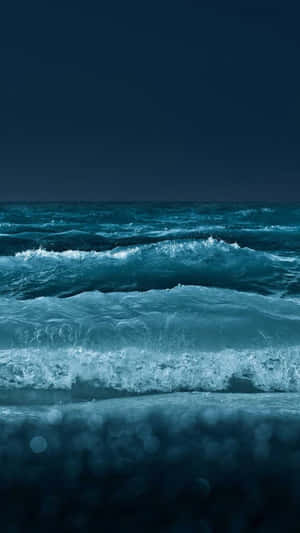 夜晚深藍色海浪拍打，前景模糊。