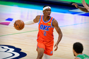 身穿橙色OKC球衣的籃球運動員在比賽中運球。