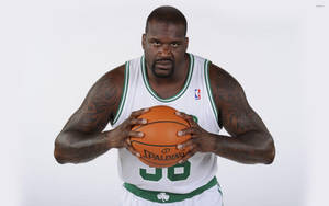 Shaquille O'Neal 身穿塞爾提克球衣在攝影棚肖像中握著籃球。 — 波士頓塞爾特人 GIF 壁紙