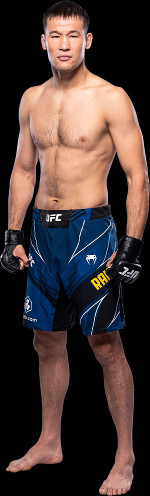 赤裸上身的MMA選手，身穿藍色UFC短褲和手套，赤腳站立在黑色背景前。