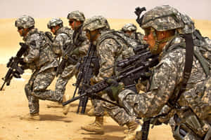一排身穿沙漠迷彩的士兵持步槍前進。