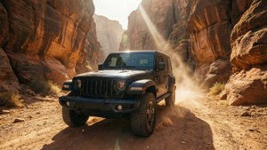 日落時分，黑色Jeep Wrangler在塵土飛揚的紅色岩石峽谷中行駛