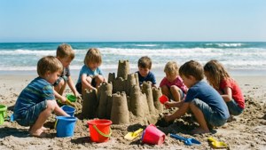 孩子們在陽光明媚的海灘上建造沙堡，伴隨著海浪。