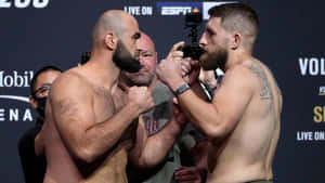 兩名赤裸上身的MMA拳手在稱重活動中面對面互相凝視。