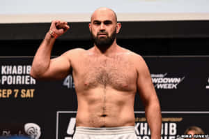 光頭鬍鬚MMA鬥士在稱重活動中彎曲右拳。 — 健身 壁紙