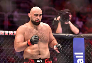 MMA戰士穿著紅色UFC短褲和黑色手套，在比賽中站在八角籠內。