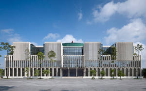 現代白色建築，帶有垂直條紋和玻璃幕牆，在藍天下。 — 唐人街 GIF 壁紙