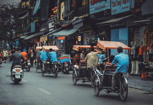 河內繁忙的街道，人力車和摩托車經過商店和人體模型。